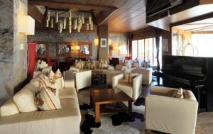 un soggiorno con divani e pianoforte a coda di Hotel Henriette a Malè