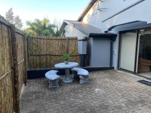 a patio with a table and two stools at 52 on Marlynhoek Self Catering Apartment in Richards Bay