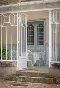 a front porch with a table and a blue door at Chateau de Maisonneuve in Leigné-les-Bois