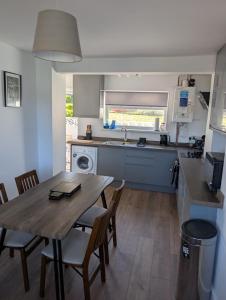 Pont-y-BeremにあるHouse in Pontyberem, Carmarthenshire - Long stays welcome!のキッチン(木製のテーブル、椅子、シンク付)