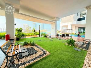 un patio avec une pelouse et des bancs dans un bâtiment dans l'établissement Midvalley Southkey Mosaic by LODGEIN -Snooker Ktv Arcade Game Kid Plyground, à Johor Bahru