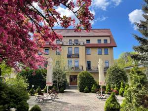 budynek ze stołami i parasolami na dziedzińcu w obiekcie Hotel Europa w Polanicy Zdroju