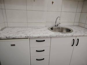 a kitchen with a sink and a white counter top at Apartmani Dream 3 in Šušanj