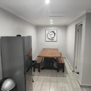 a dining room with a wooden table and a refrigerator at 52 on Marlynhoek Self Catering Apartment in Richards Bay +8 photos
