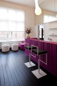 een keuken met een paarse bar met krukken bij B&B Suites FEEK in Antwerpen