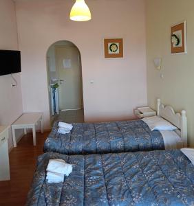 a hotel room with two beds and a table at Firefly Studios Georgios 12 in Moraitika