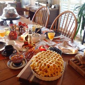 a wooden table with a waffle and food on it at Our Valley View Bed & Breakfast in Hampton +33 photos