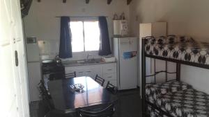 a small kitchen with a table and a bunk bed at Complejo sierras de brochero in Villa Cura Brochero +4 photos