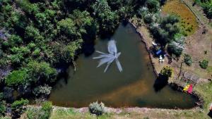 an aerial view of a windmill in a lake at Loft 4 Sítio Cachoeiras do Caledônia in Nova Friburgo +51 photos