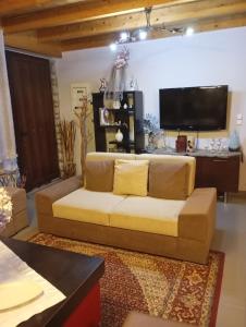 a living room with a couch and a flat screen tv at Αρχωντικα στην Τρiχονιδα in Agrinio