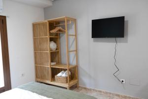 トレドにあるHabitación Independiente Cristo de la luzの本棚と壁掛けテレビ付きの部屋