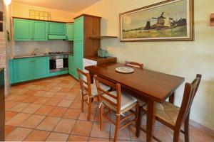 una cocina con armarios verdes y una mesa y sillas de madera. en Villa Agello Vista Lago, en Agello 22 fotos más