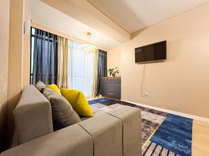 a living room with a couch and a flat screen tv at ЖК Nomad KZ Almaty in Zhezdi