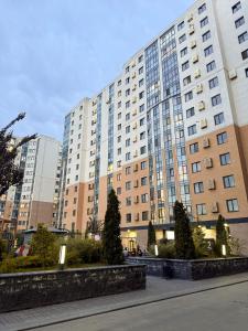 a large tall building with trees in front of it at ЖК Nomad KZ Almaty in Zhezdi