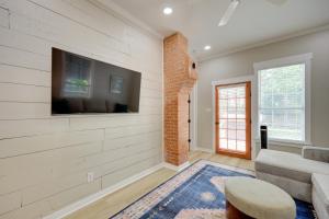 Una sala de estar con un sofá y un televisor en una pared. en San Antonio Home 2 Mi to Dtwn, Swim Spa!, en San Antonio