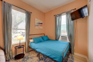 Un dormitorio con una cama con sábanas azules y una ventana. en San Antonio Home 2 Mi to Dtwn, Swim Spa!, en San Antonio 19 fotos más