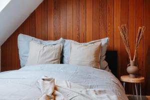 ein Bett mit weißen Laken und Kissen in einem Schlafzimmer in der Unterkunft Rooftop-Apartment zentral gelegen in Düsseldorf in Düsseldorf