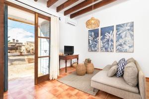ein Wohnzimmer mit einer Couch und einer Glasschiebetür in der Unterkunft Casa Antigua in Santanyi