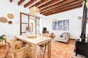 ein Wohnzimmer mit einem Holztisch und Stühlen in der Unterkunft Casa Antigua in Santanyi