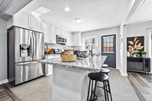 a kitchen with white cabinets and a granite counter top at East Atlanta Retreat with 2 Homes Sleeps 16 and Pet Friendly in Decatur