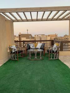 a patio with a green carpet on a balcony at Elsokhna BlueBay Asia For families only in Ain Sokhna