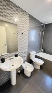 a bathroom with two sinks and a toilet and a mirror at Apartamenticos Living San Pablo in Zaragoza