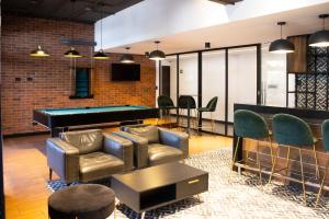 a living room with a pool table and chairs at Corazón urbano, apartamento Guatemala zona 10 EON in Guatemala