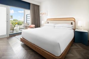 Un dormitorio con una cama blanca y un balcón. en Verdanza Hotel, en San Juan