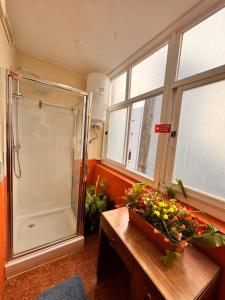een badkamer met een douche en een tafel met bloemen bij Samba Guesthouse in Porto +63 foto's
