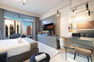 a bedroom with a bed and a desk with a laptop at Cosy Studio, 7-min walk Burj Khalifa and Dubai Mall in Dubai