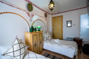 a bedroom with two beds and a clock on the wall at Dar AL BARAKA in Tangier