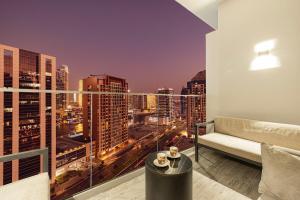 a living room with a couch and a view of a city at Cosy Studio, 7-min walk Burj Khalifa and Dubai Mall in Dubai