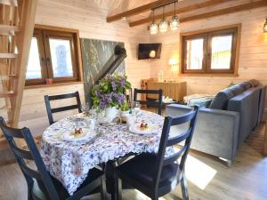 a dining room with a table with flowers on it at Leśne Dziady Borsk in Borsk