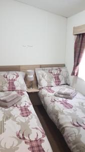 two beds sitting next to each other in a bedroom at Jasper Lodge in Beautiful Glendevon Country Park Perthshire Scotland in Glendevon