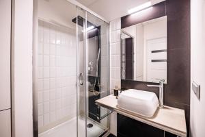 un baño con lavabo y ducha en About Art Apartments - Ovo, en Wroclaw 73 fotos más