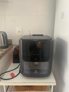 a microwave sitting on top of a shelf at Mediterrâneo 507 - Todo Equipado, Ar Condicionado, Churrasqueira na Varanda, Internet Fibra 600MB, Estacionamento Grátis in Cabo Frio