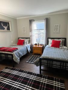a bedroom with two beds and a window at Belvidere Mountain Vista Home by Stowe Jay Peak Smuggs Long Trail in Belvidere Center +25 photos