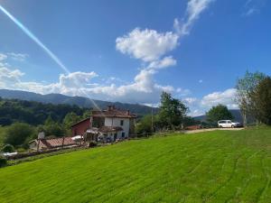 a house on a hill with a green field at Casa Aldea l'Ayalga in Beloncio