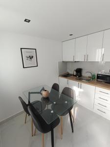 a kitchen with a glass table and two chairs at kallithea maisonette in Kallithea Halkidikis