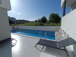 a swimming pool with chairs and a table and a swimming pool at kallithea maisonette in Kallithea Halkidikis