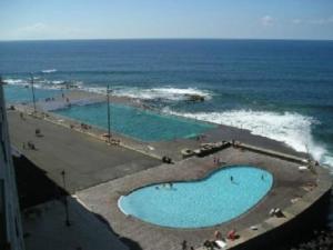 an aerial view of two swimming pools near the ocean at Balcon al mar in Bajamar +9 photos