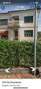 a house with a hedge in front of a building at Inti in Lucca