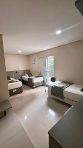 a large room with two beds and a window at Trade Hotel Diadema in Diadema