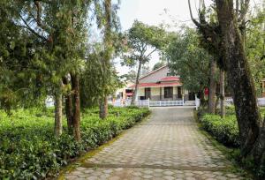 a brick road leading to a house with trees at Karuniagiri Guest House in Jāmb