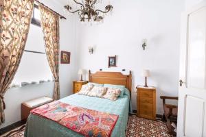 a bedroom with a bed and a chandelier at Casa El Balcón de La Punta in Hermigua