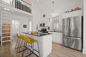 una cucina con mobili bianchi e un frigorifero in acciaio inossidabile di L'Hibou - 18 Farm View a Cherry Valley