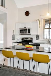 una cucina con bancone e sedie gialle di L'Hibou - 18 Farm View a Cherry Valley