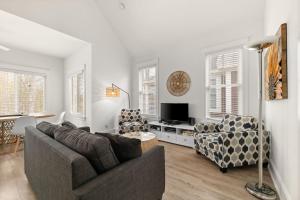 un soggiorno con divano, sedie e TV di L'Hibou - 18 Farm View a Cherry Valley Altre 72 foto