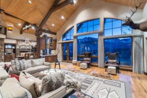 un grand salon avec de grandes fenêtres et un salon avec une tête de cerf dans l'établissement Luxury Telluride Retreat Hot Tub and Mountain View, à Telluride