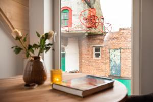 a book on a table with a vase and a window at B&B 't Molenerf in Wingene